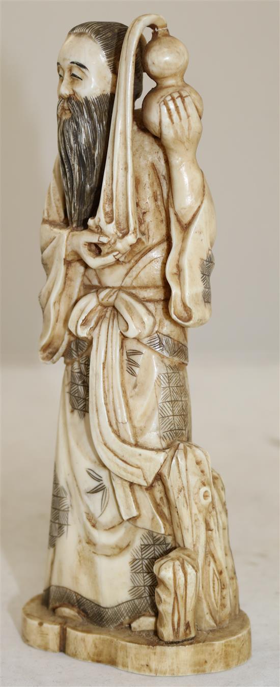 A Japanese walrus ivory figure of a man pouring water from a gourd, early 20th century, height 21cm